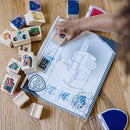 Child creating PAW Patrol scenes with wooden stamps and activity pad