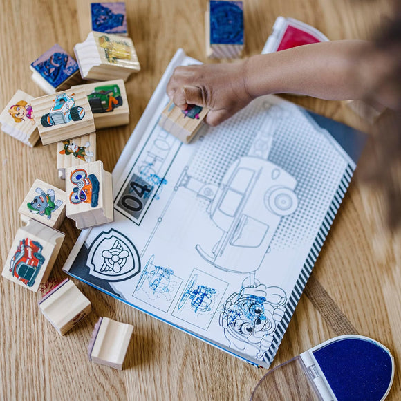 Child creating PAW Patrol scenes with wooden stamps and activity pad